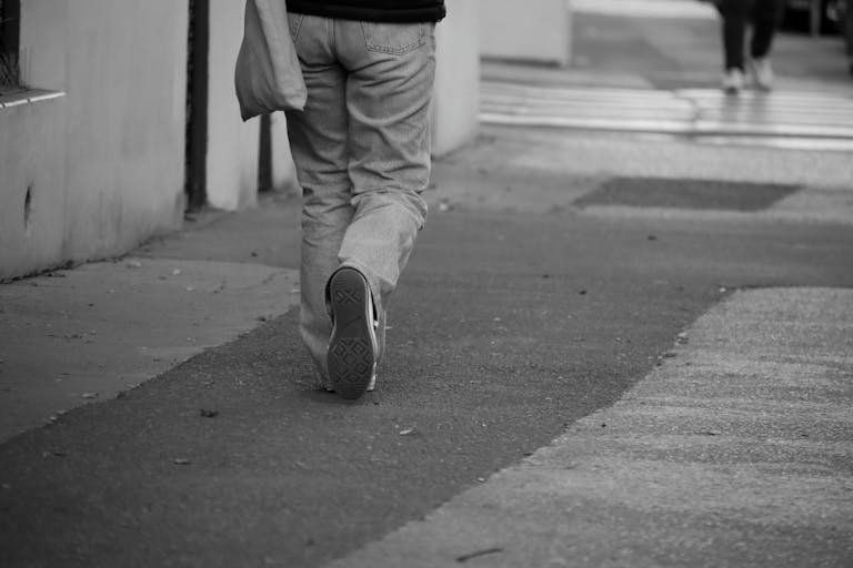 Person walking away on a city street, representing short-term therapy