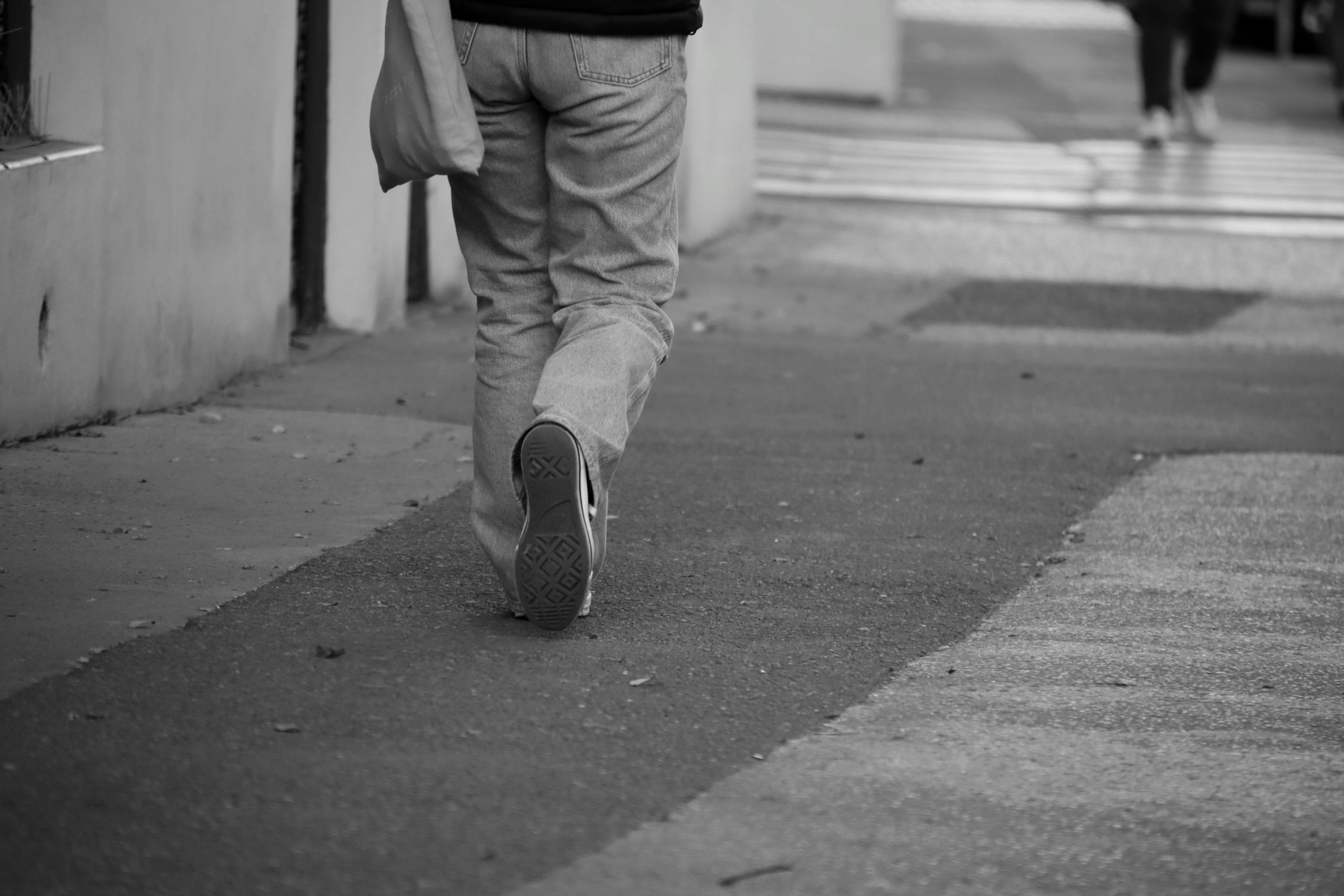 Person walking away on a city street, representing short-term therapy