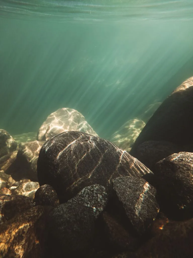 Sunlit rocks under ocean waters capturing a serene underwater environment, depicting the depth of long-term therapy.